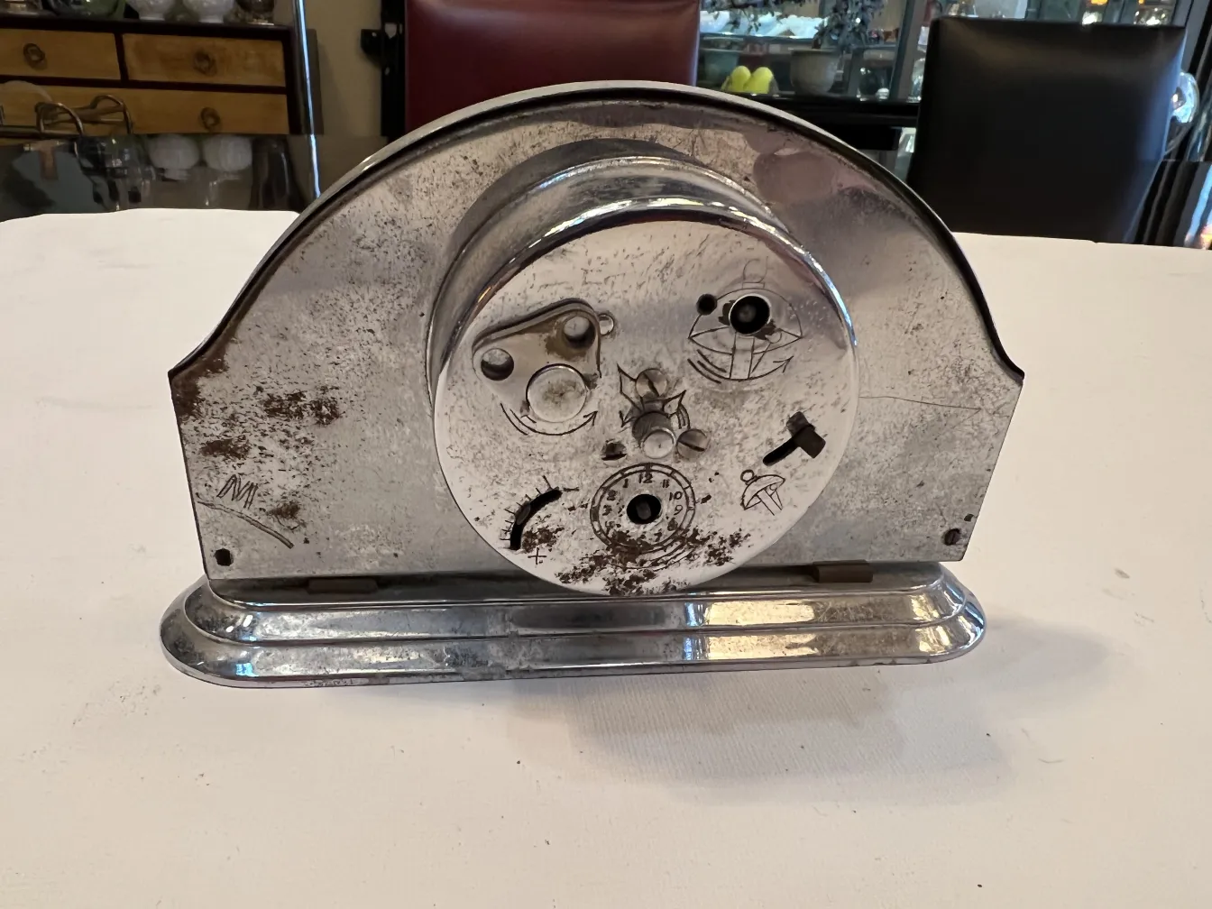 Relógio de mesa antigo com características distintas e desgaste visível.