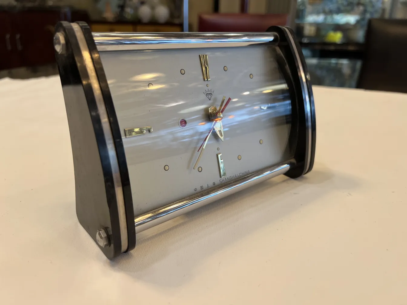 relógio de mesa antigo com design curvado e ponteiros dourados