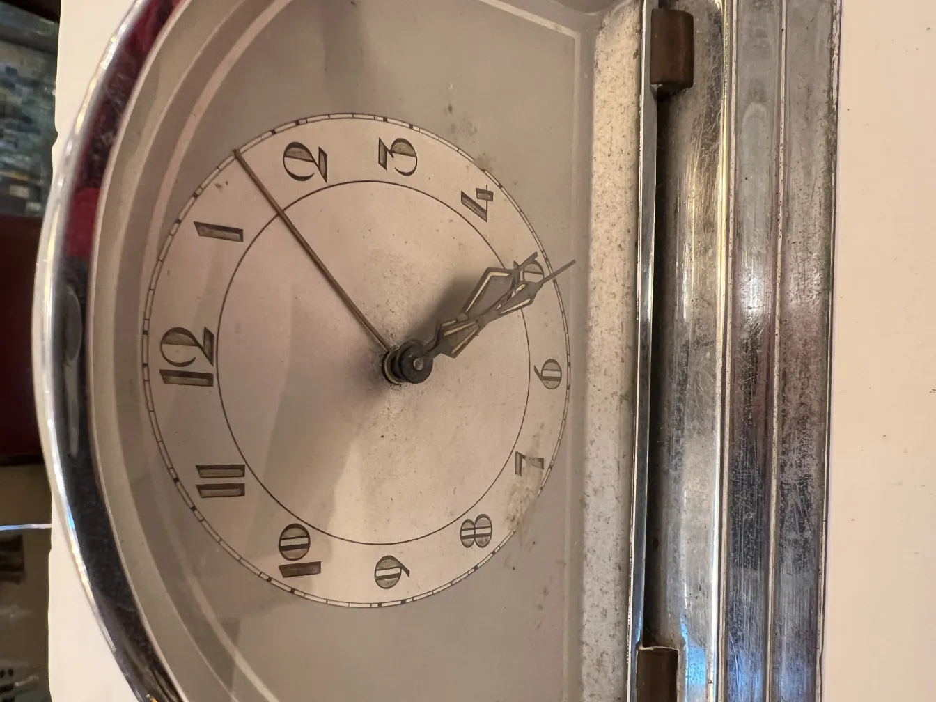 Reloj antiguo de pared con números romanos y agujas clásicas, en un entorno acogedor.