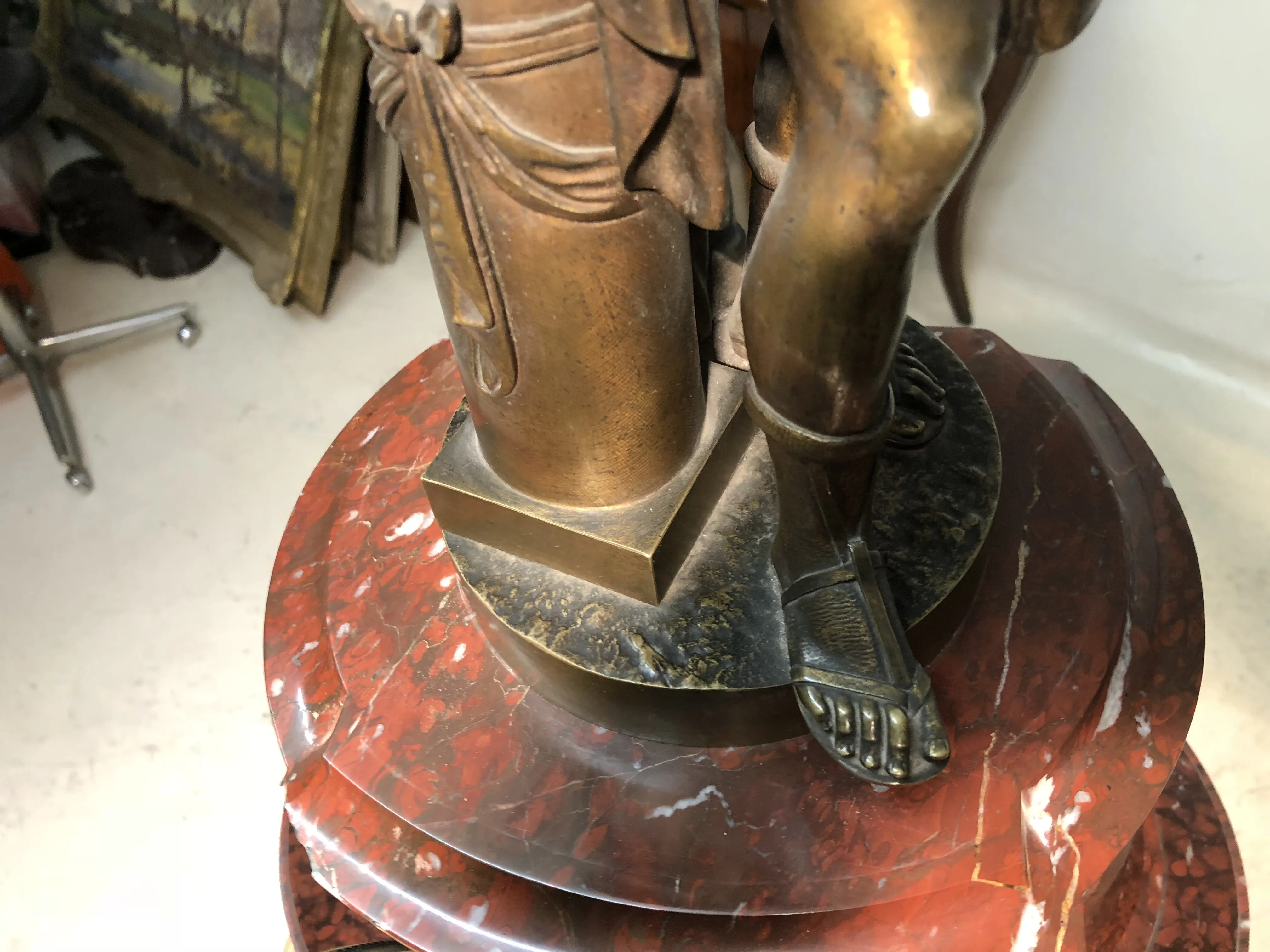 horloge ancienne sculptée avec des détails décoratifs sur un socle rond