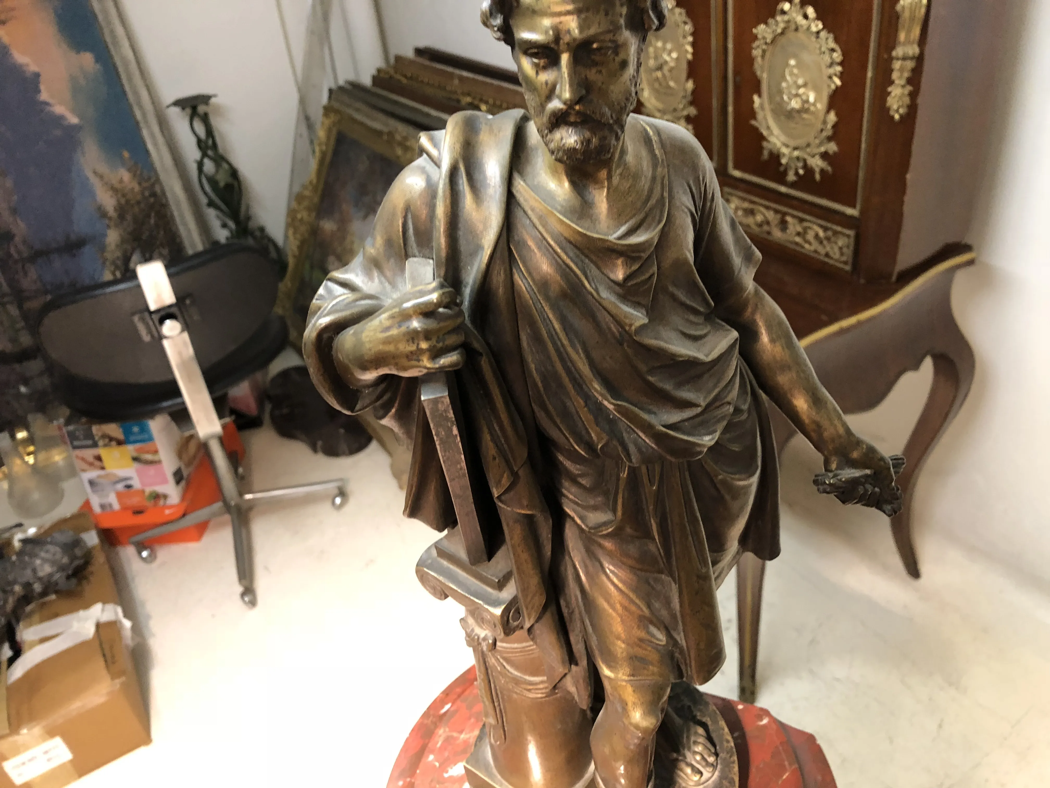 orologio antico decorativo con figura maschile che tiene un oggetto, sfondo di antiquariato