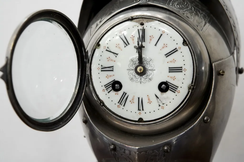 verziertes antikes Uhr mit Kerzenleuchtern im Hintergrund