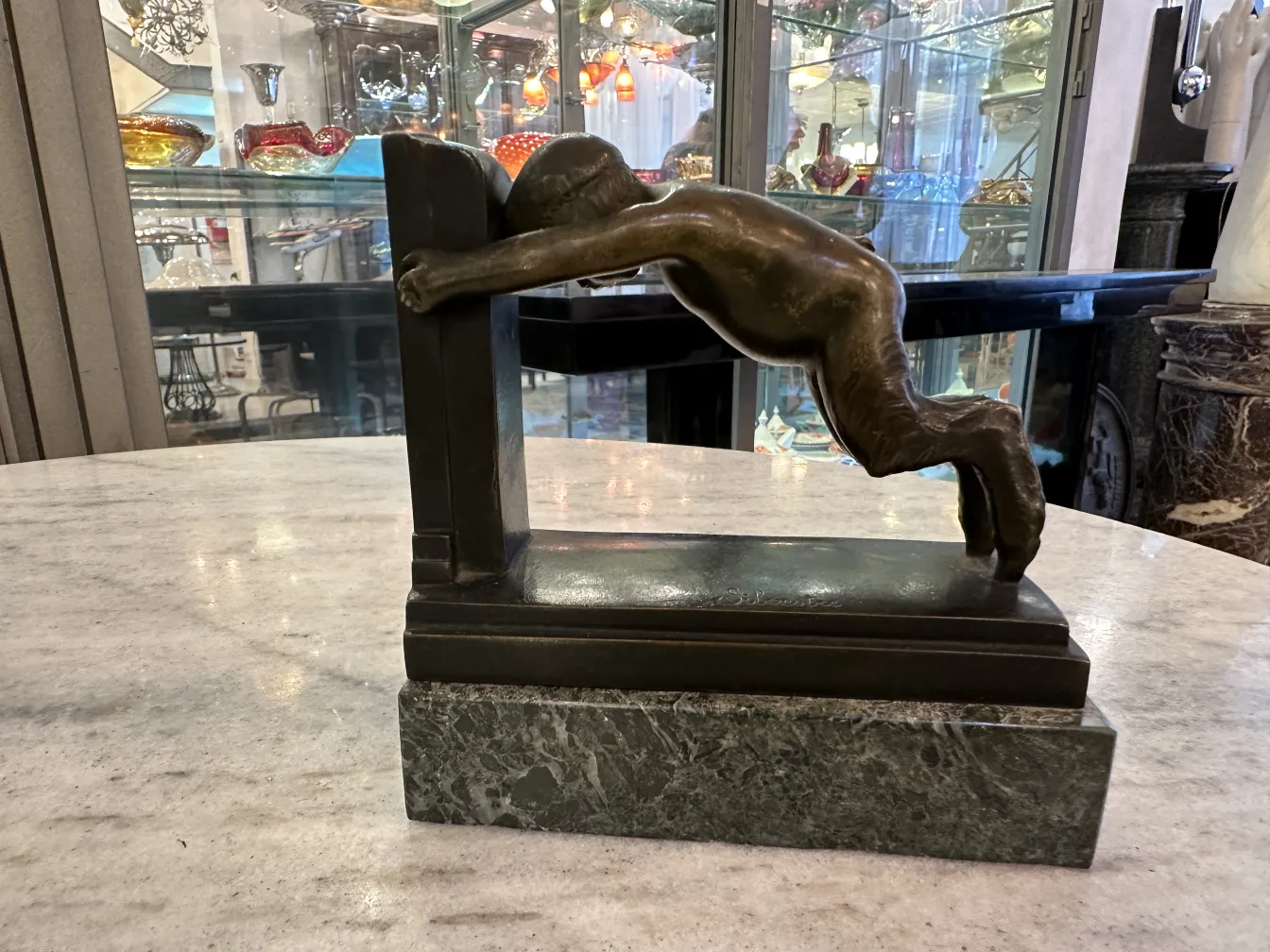 Antique bookends featuring a bronze sculpture on a marble base.