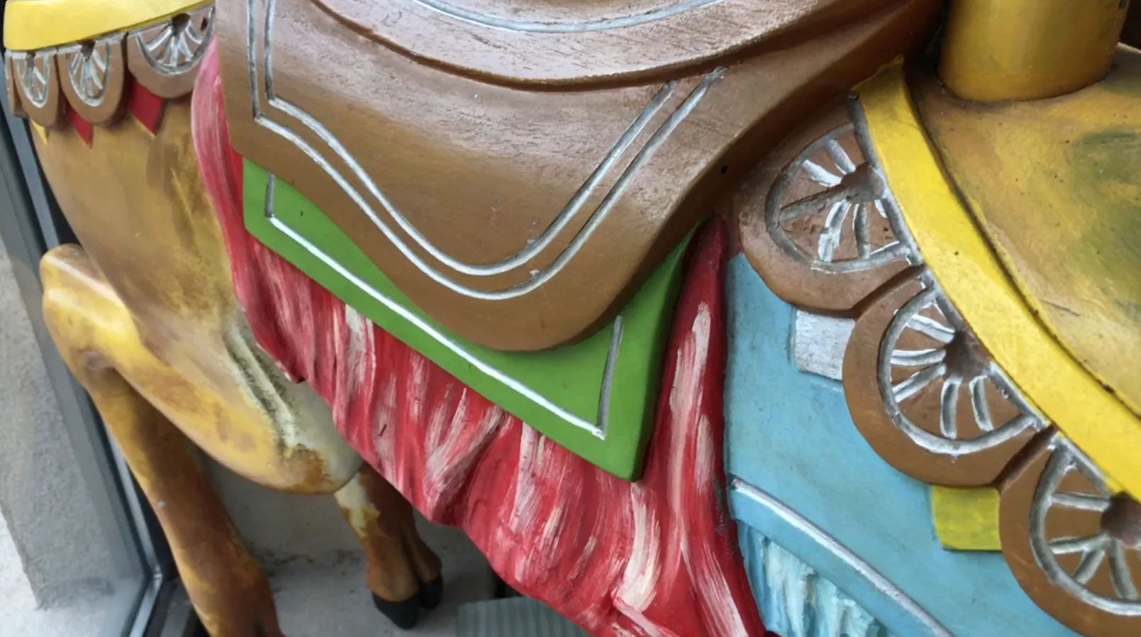 Figura de llama antigua con colores vibrantes y detalles decorativos.