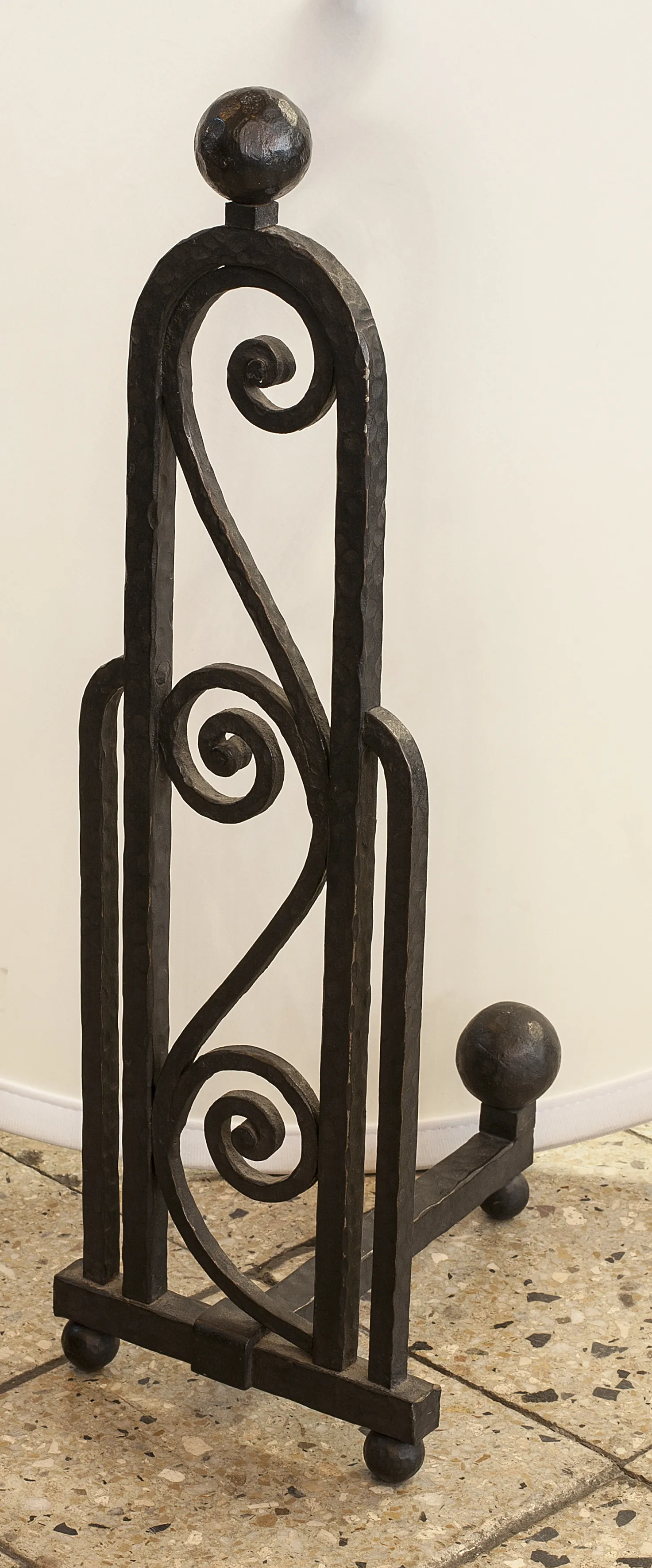 Antique iron andirons featuring curved design and spherical tops