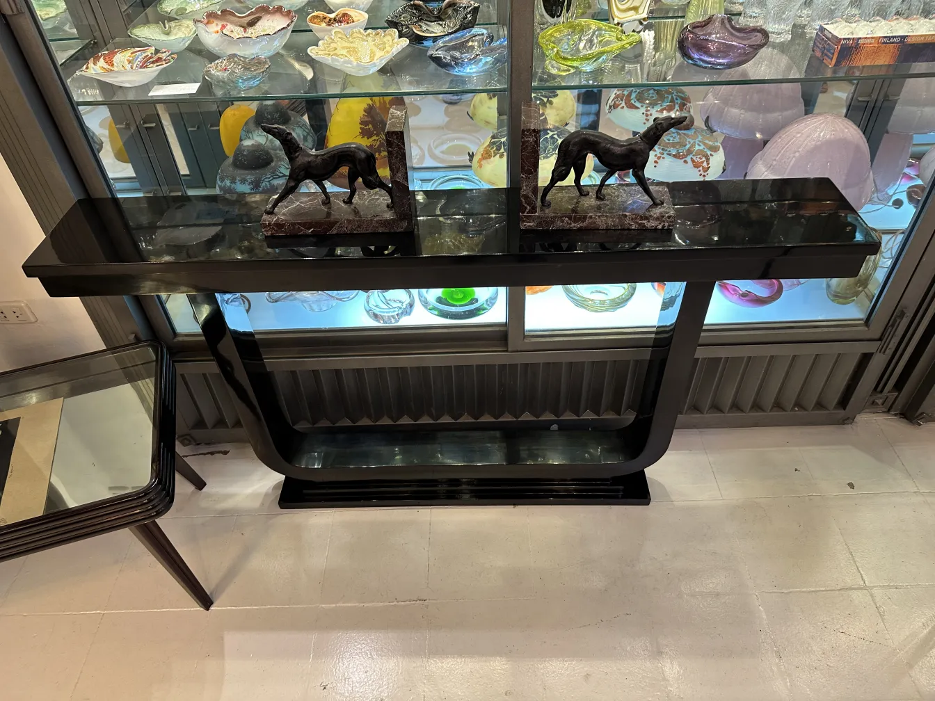 Antigos suportes para livros com figuras de cavalos em uma mesa preta, cercados por decoração vintage