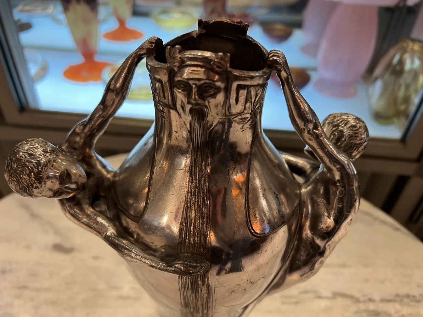 vaso antigo com duas figuras segurando a borda