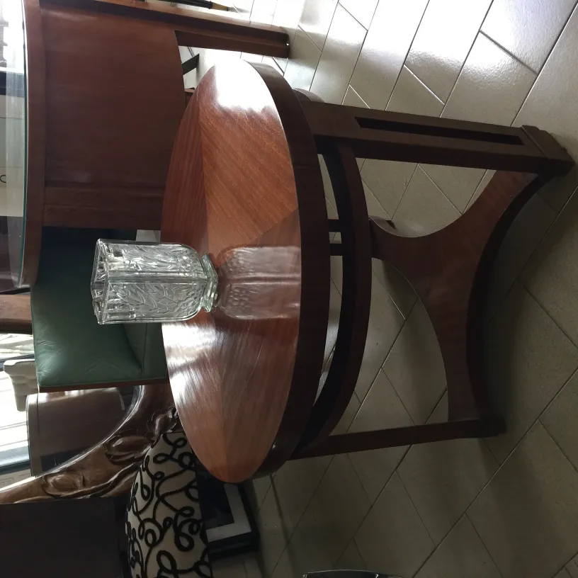 vaso de flores antigo em uma mesa com cadeiras ao fundo