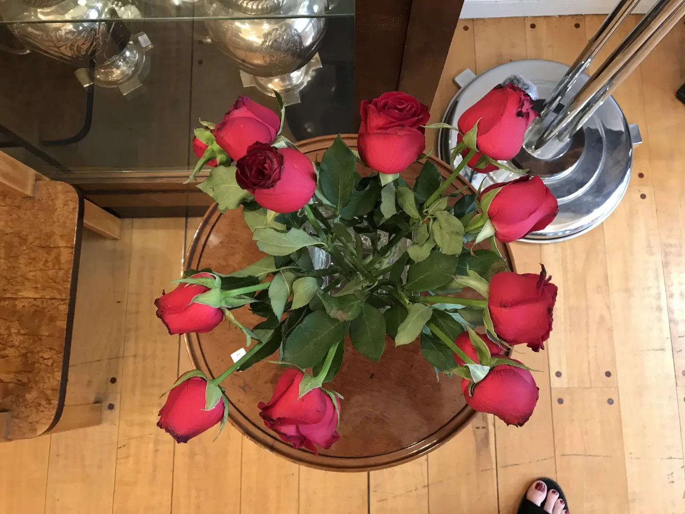 florero antiguo en mesa de madera con rosas