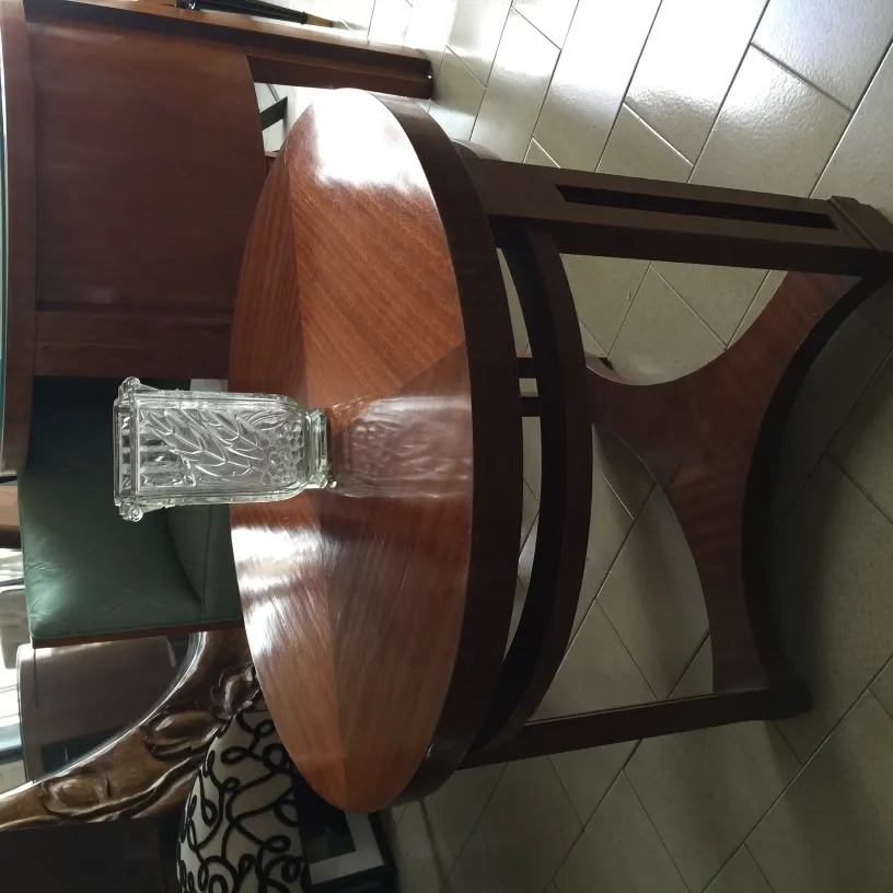 vase ancien décoratif en verre sur table en bois, avec chaise en arrière-plan