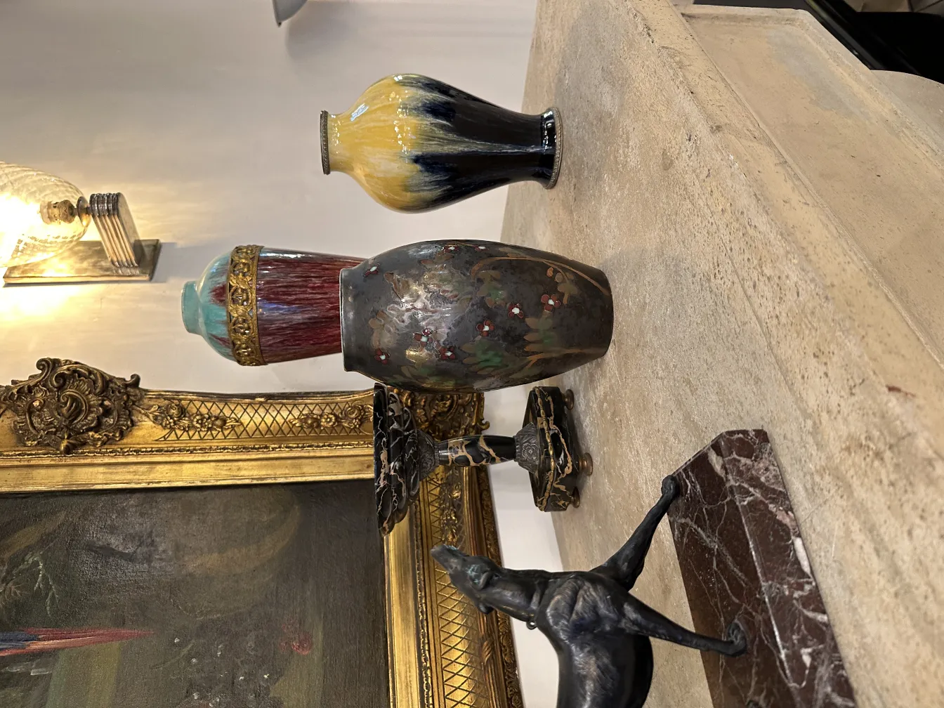 Suportes para livros antigos decorativos em uma mesa com vasos.