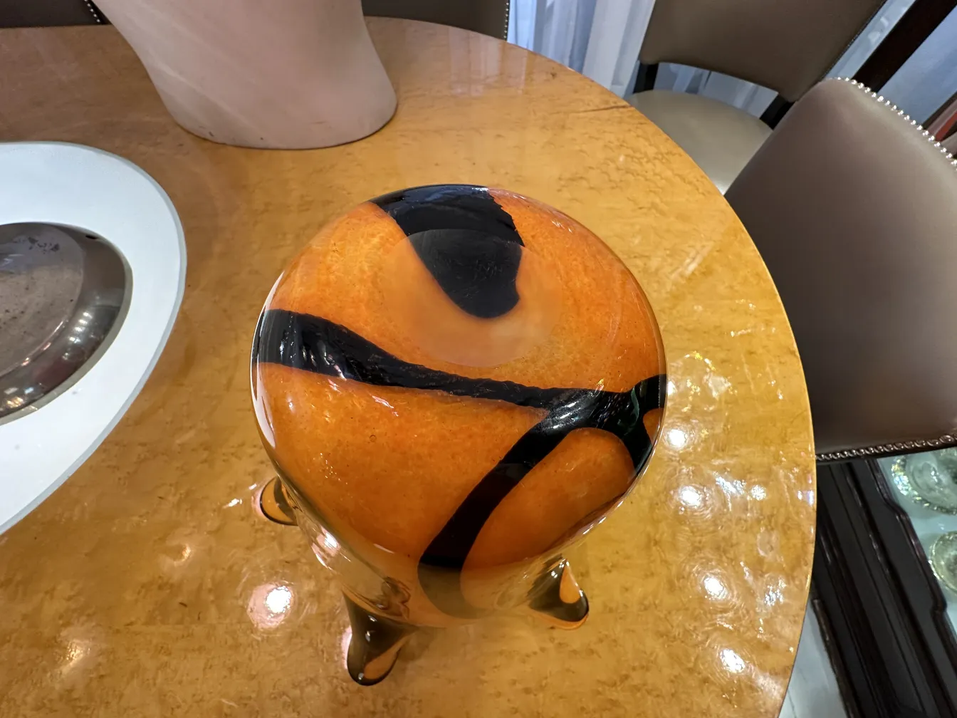 vase mit warmen Farben und auffälligen Mustern auf einem Tisch