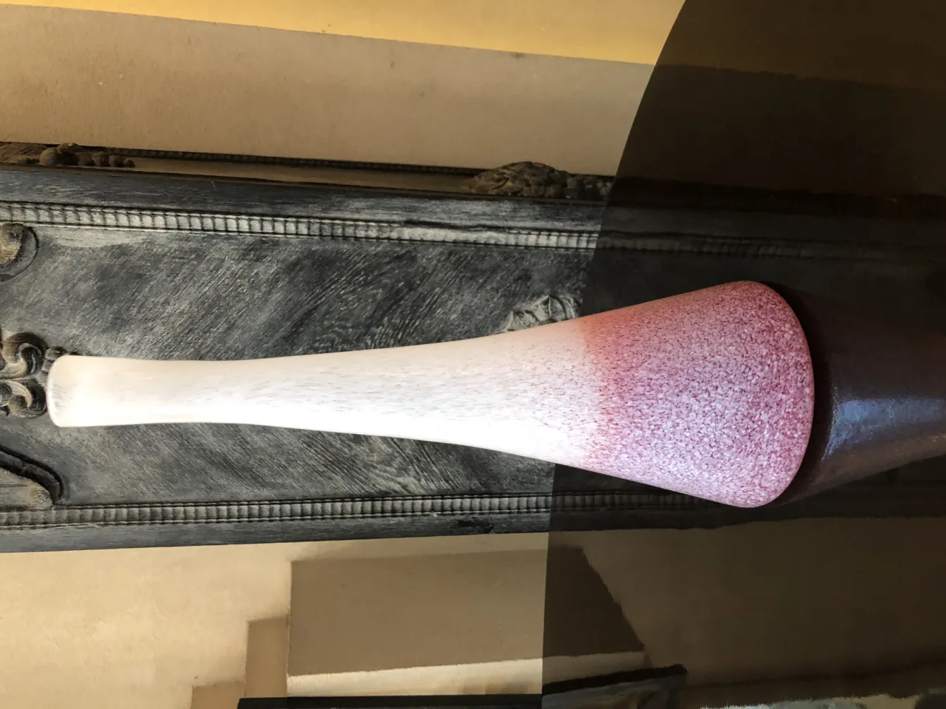 florero antiguo de forma alargada en tonos rosados