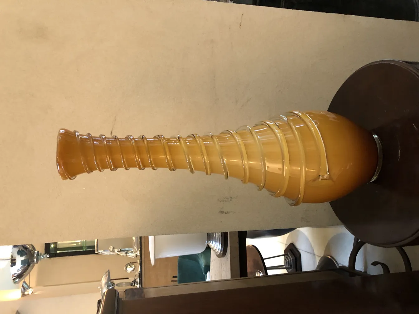 Vaso antico stilizzato di colore ambra, ambiente elegante.