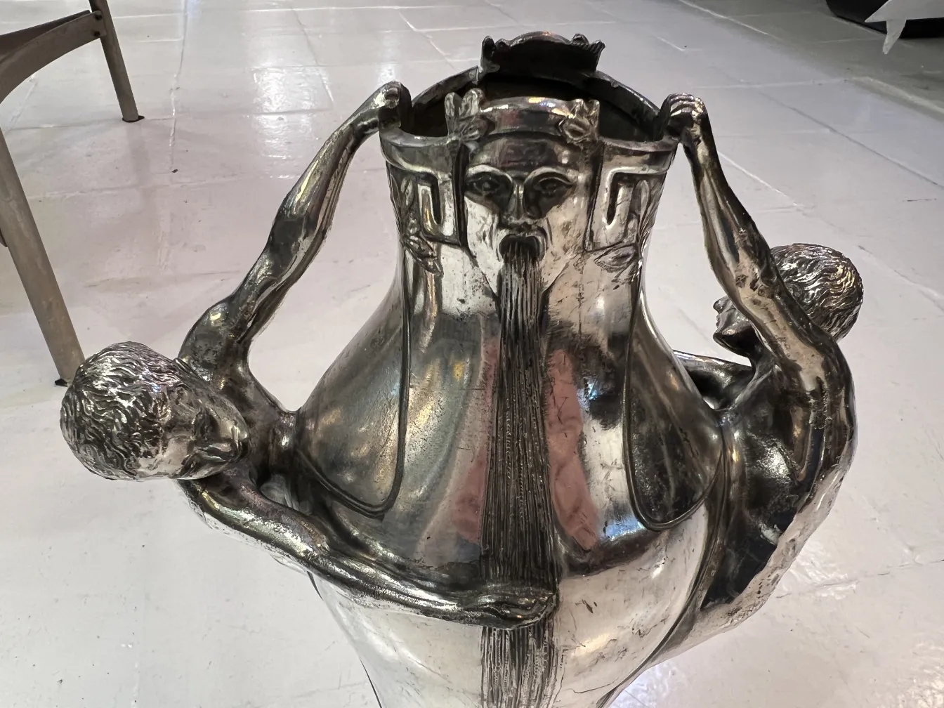 vaso antigo com detalhes esculturais de figuras humanas