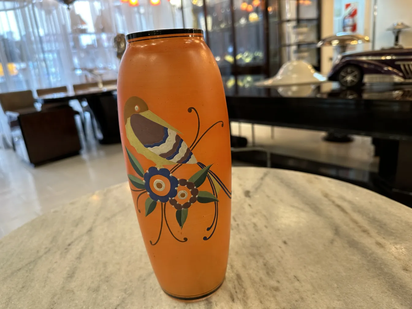 vase ancien de couleur orange avec un décor floral et un oiseau