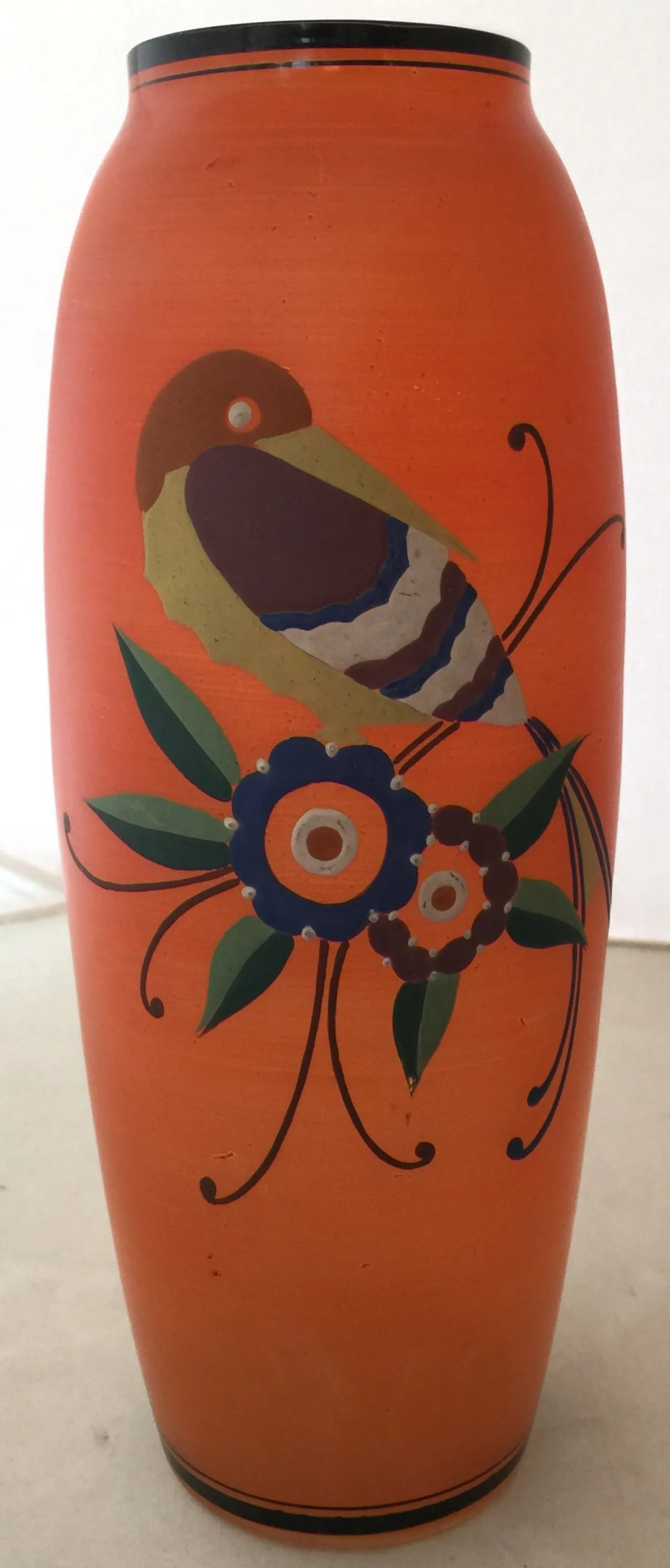 vase ancien brillant avec des illustrations d'oiseaux et de fleurs sur un fond orange
