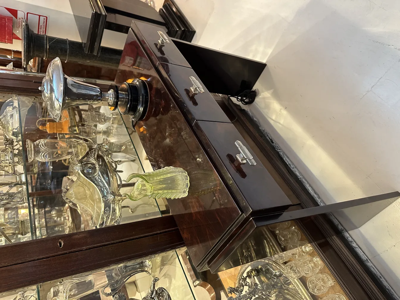 Старинная зеленая ваза с рифлеными деталями, окруженная декоративными предметами