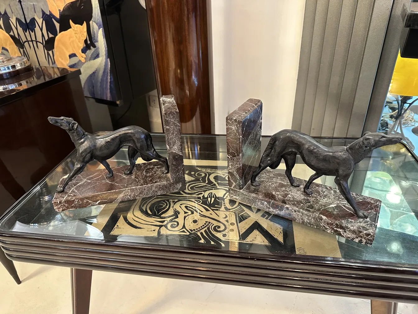 Estatuillas de perros como aprieta libros sobre mesa de vidrio.