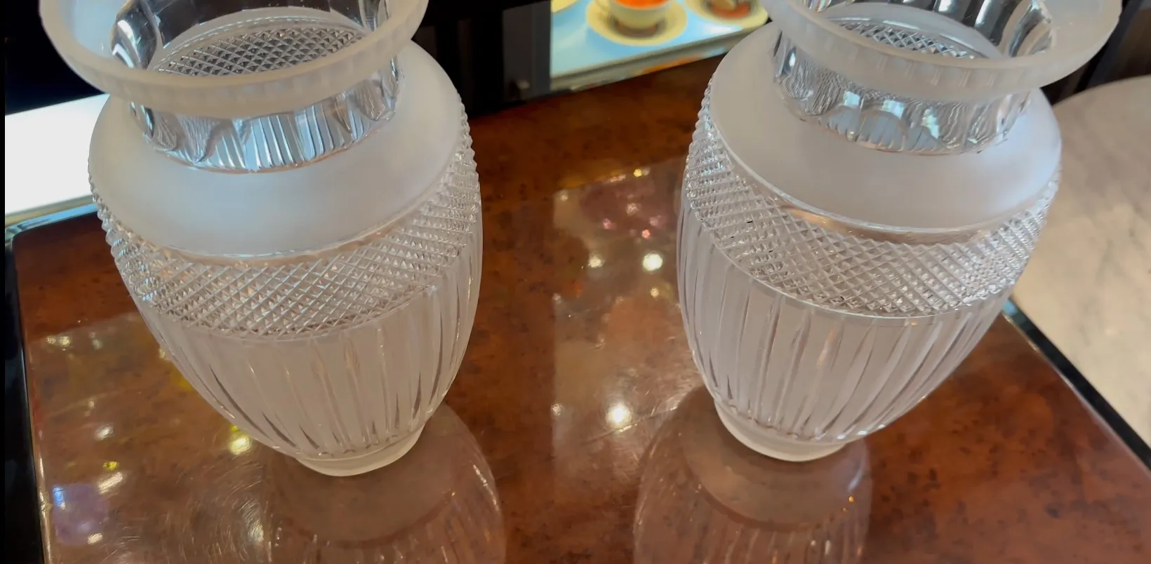 Dois vasos decorativos antigos em um ambiente elegante com brilho sutil.