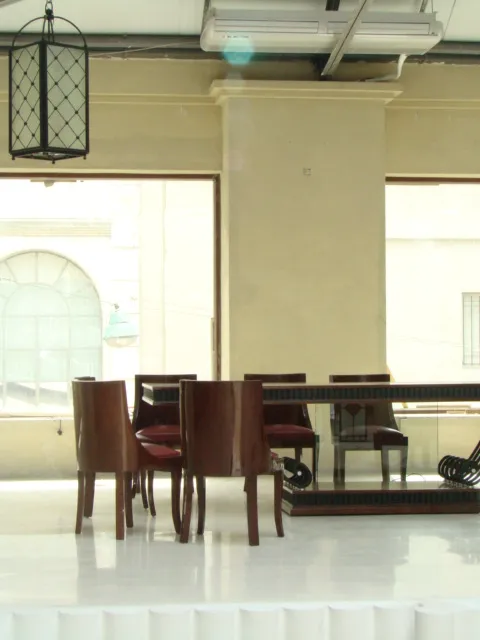 Table à manger ancienne avec chaises dans un cadre vaste et moderne.