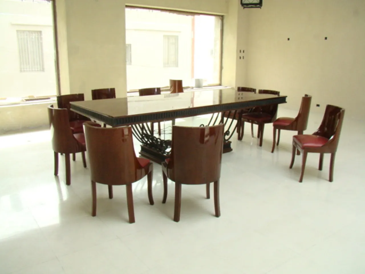 Table à manger antique de style Art Deco pour 12 personnes, entourée de chaises modernes.