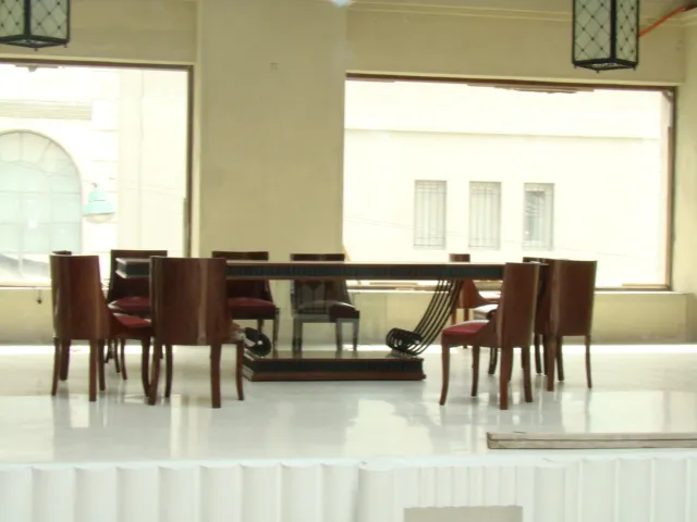 طاولة طعام قديمة مع كراسي في مكان مضيء