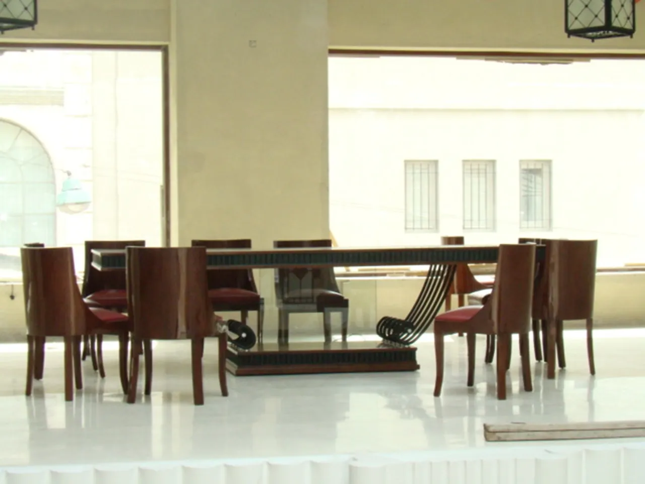 Mesa de comedor antigua en un ambiente claro, con sillas alrededor.