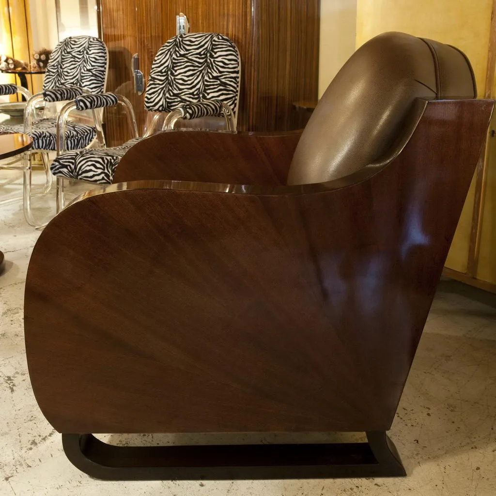 Due poltrone antiche con un design curvo e stilizzato. Sfondo con poltrone a righe.