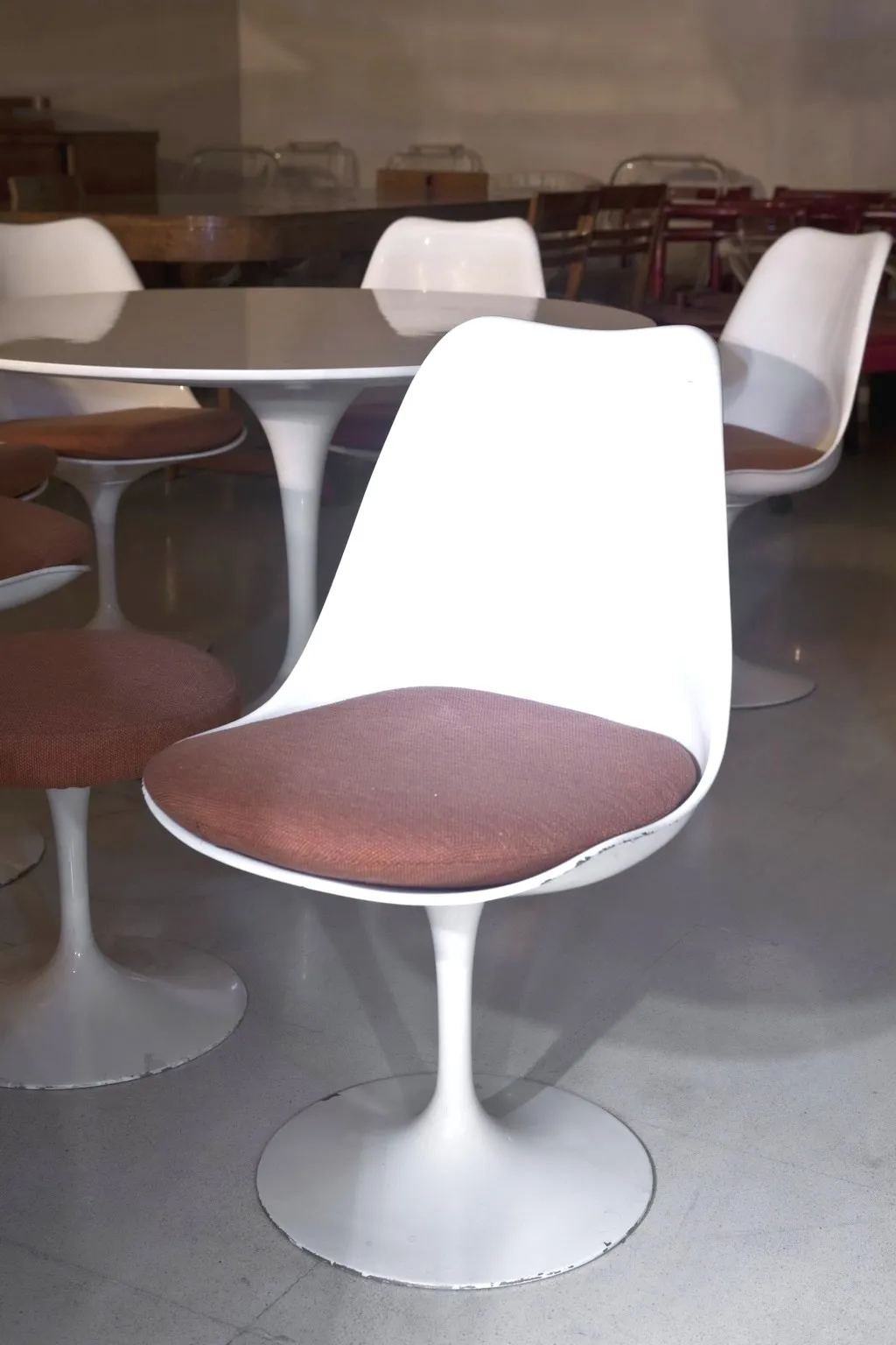 tavolo da pranzo antico per sette persone in un ambiente accogliente con sedie bianche.