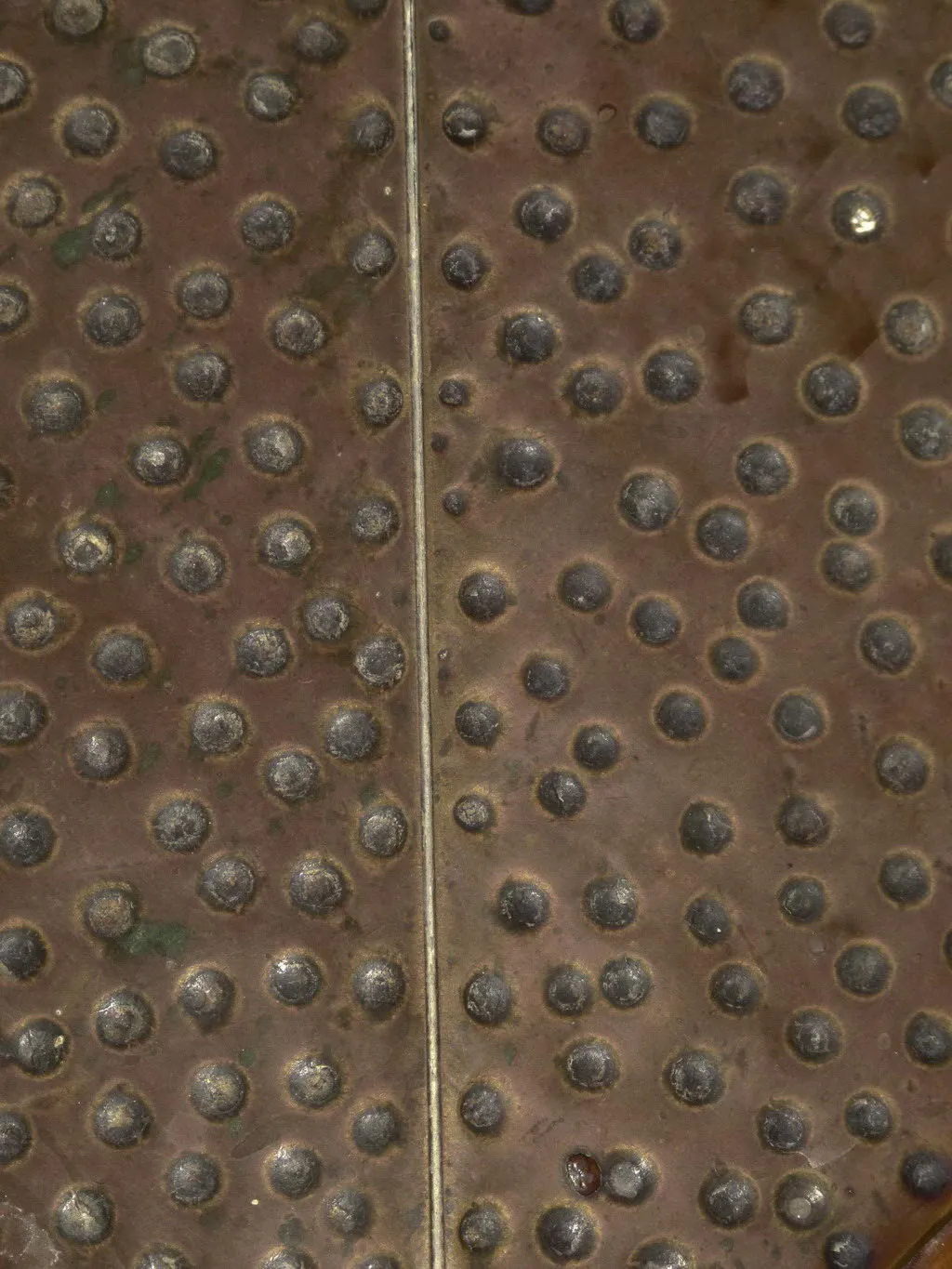 Table à manger antique avec des rivets, atmosphère chaleureuse.