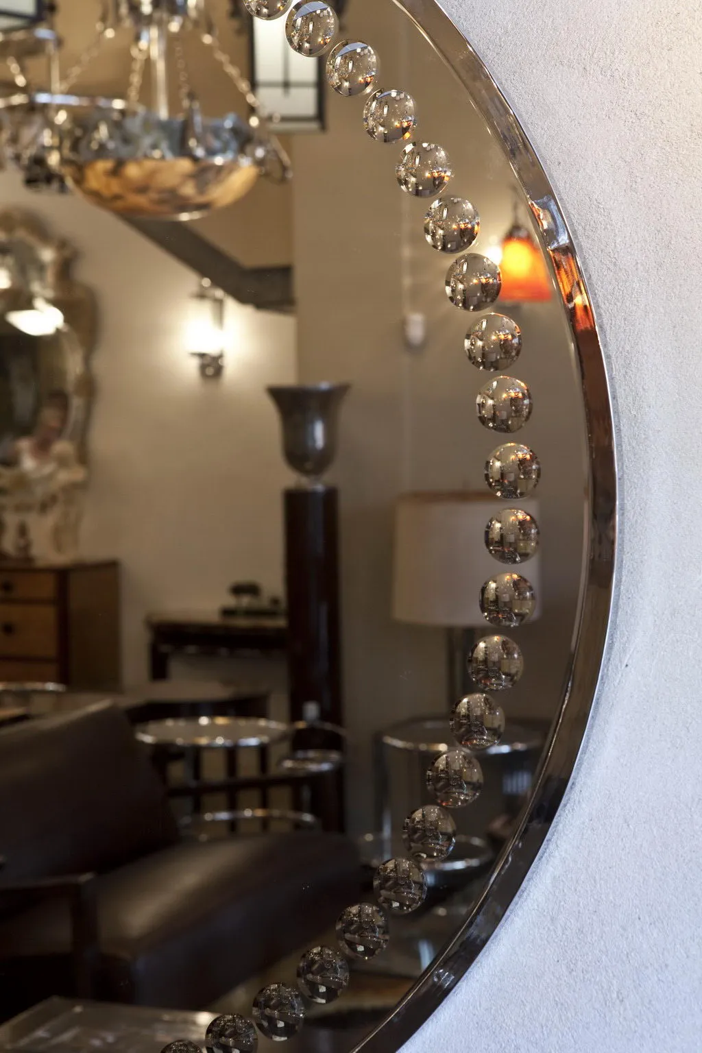 antique art deco mirror with a round shape and decorative details, surrounded by an elegant setting