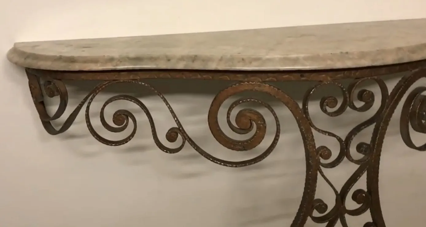 Consola antigua con un diseño artístico de curvas en hierro.