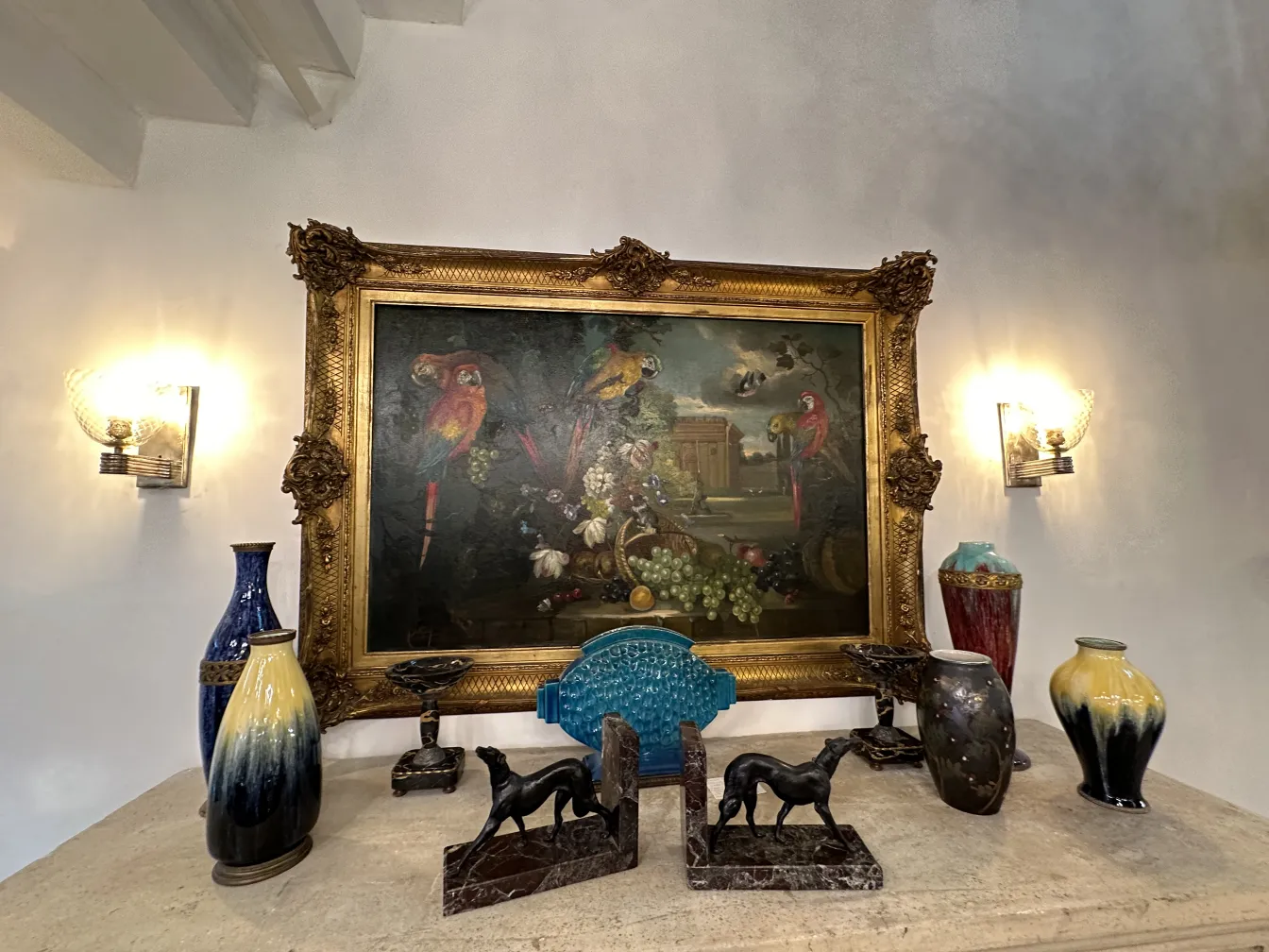 Antique decorative bookends with elegant design next to a painting.