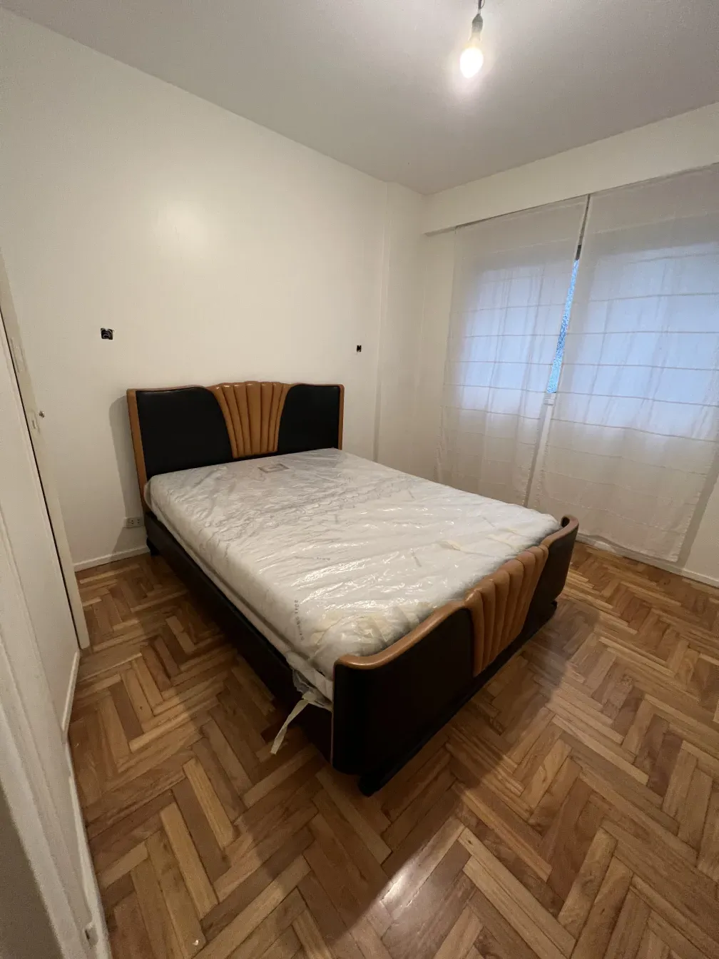 Letto antico in una stanza con luce naturale e pavimenti in legno.