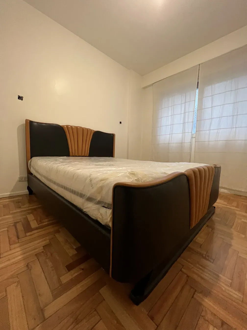 Antikes Bett im Art Deco-Stil mit dekorativem Kopfteil.