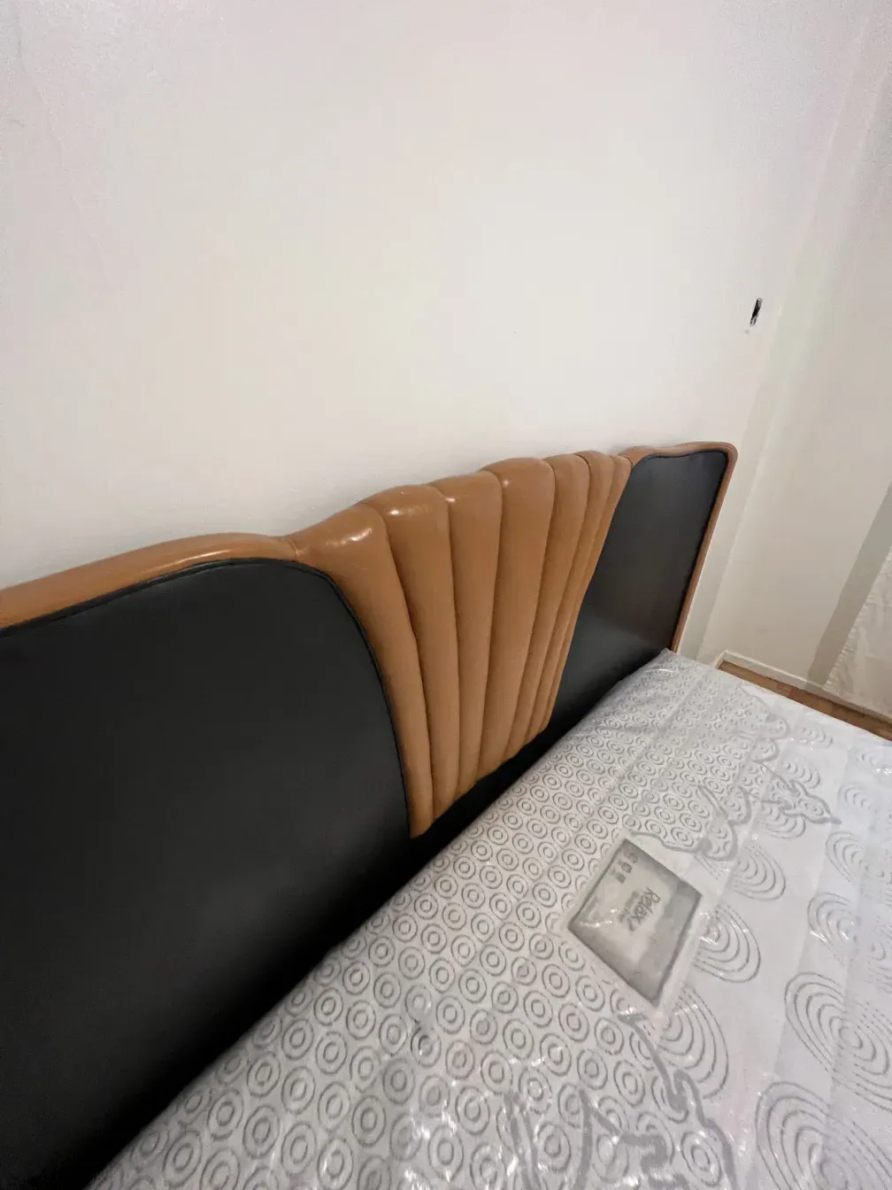 Letto antico in stile Art Deco con testata decorativa in toni chiari e scuri.