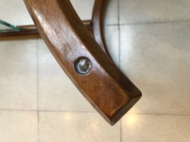 Detalhe de uma mesa antiga para 8 pessoas com acabamento em madeira.