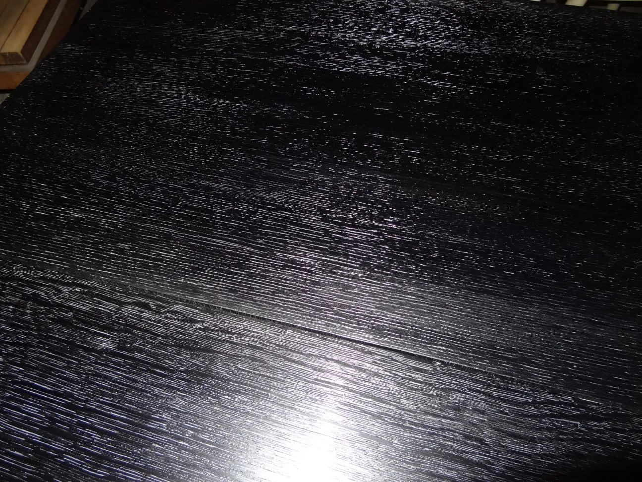 glänzende schwarze Oberfläche eines antiken Konsolentischs