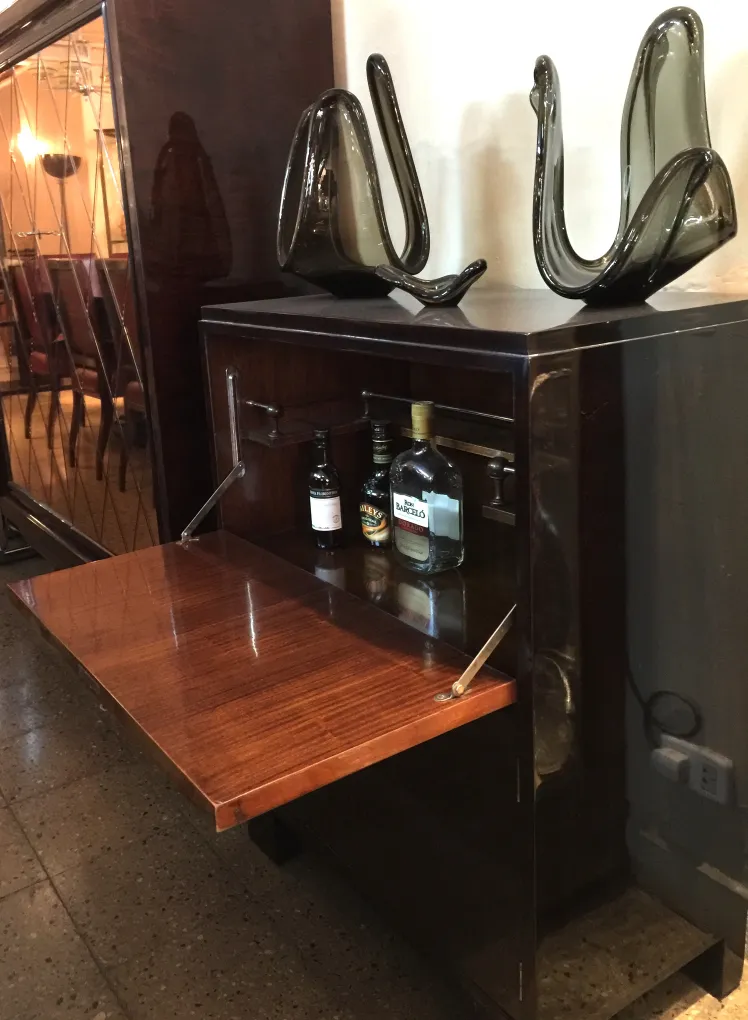 Antiguo mueble bar con superficie brillante y abertura frente.