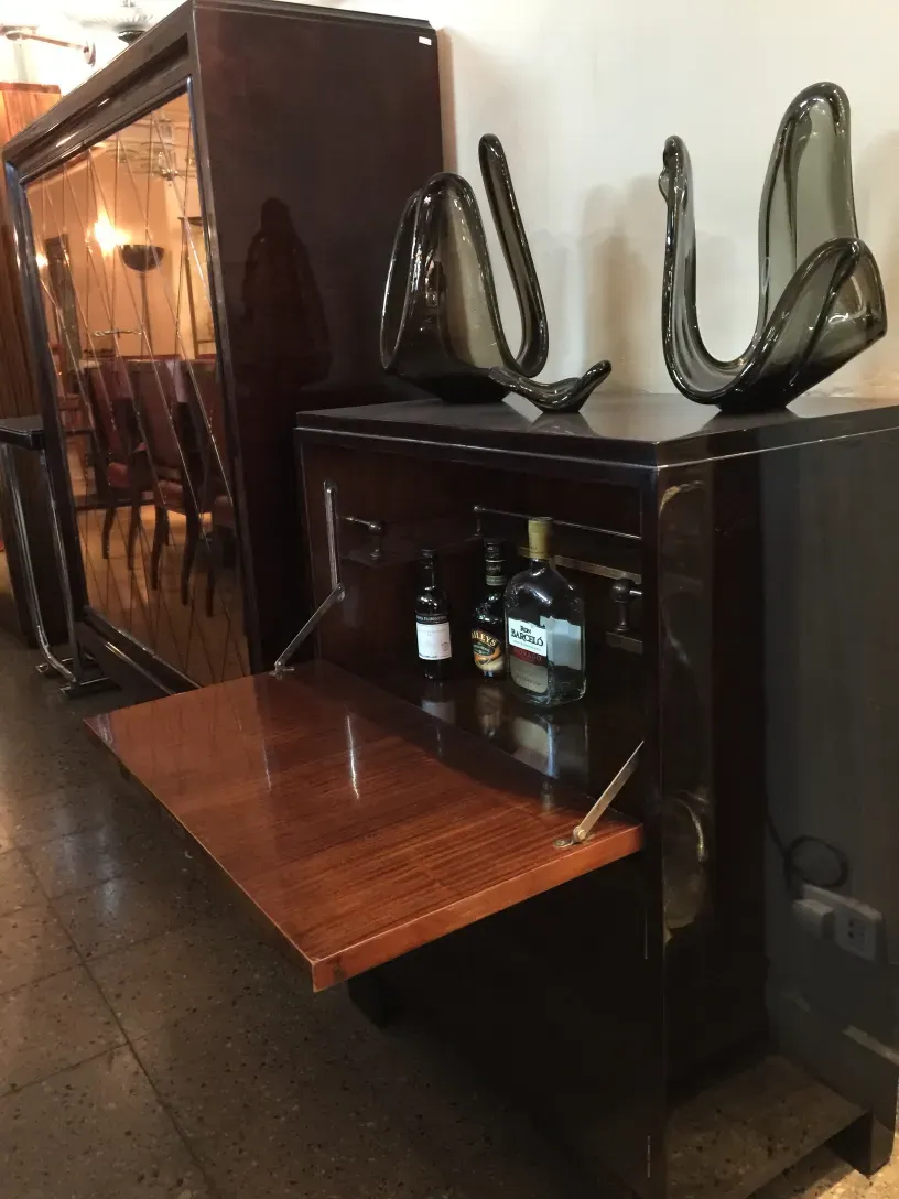 Antique wooden bar cabinet with bottles and elegant decor.