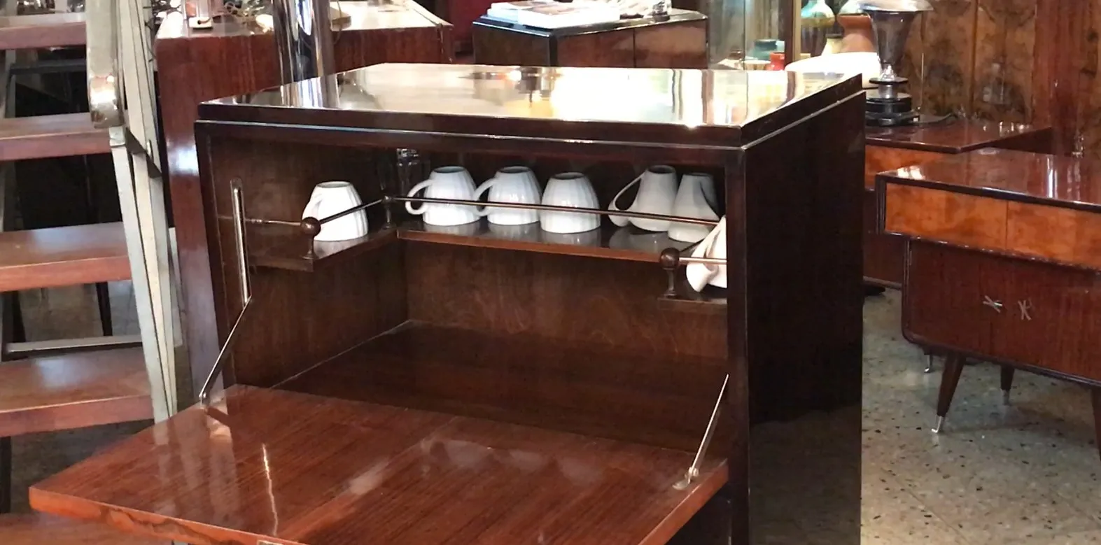 Móvel bar antigo com xícaras e um ambiente elegante