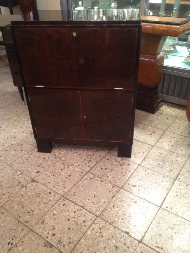 Meuble à cocktail antique avec portes en bois foncé dans un cadre élégant.