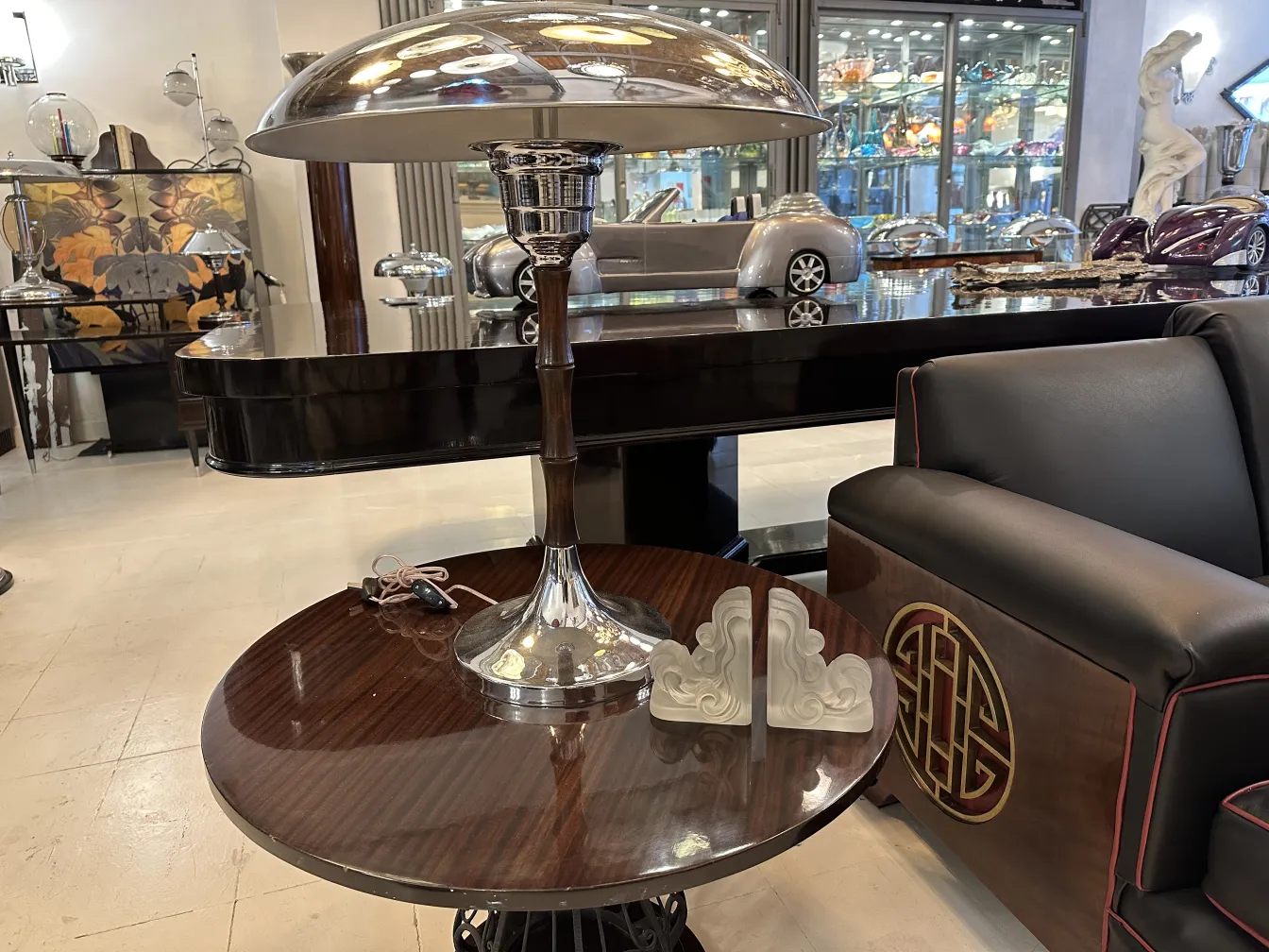 Antique bookends on a table next to a modern lamp.