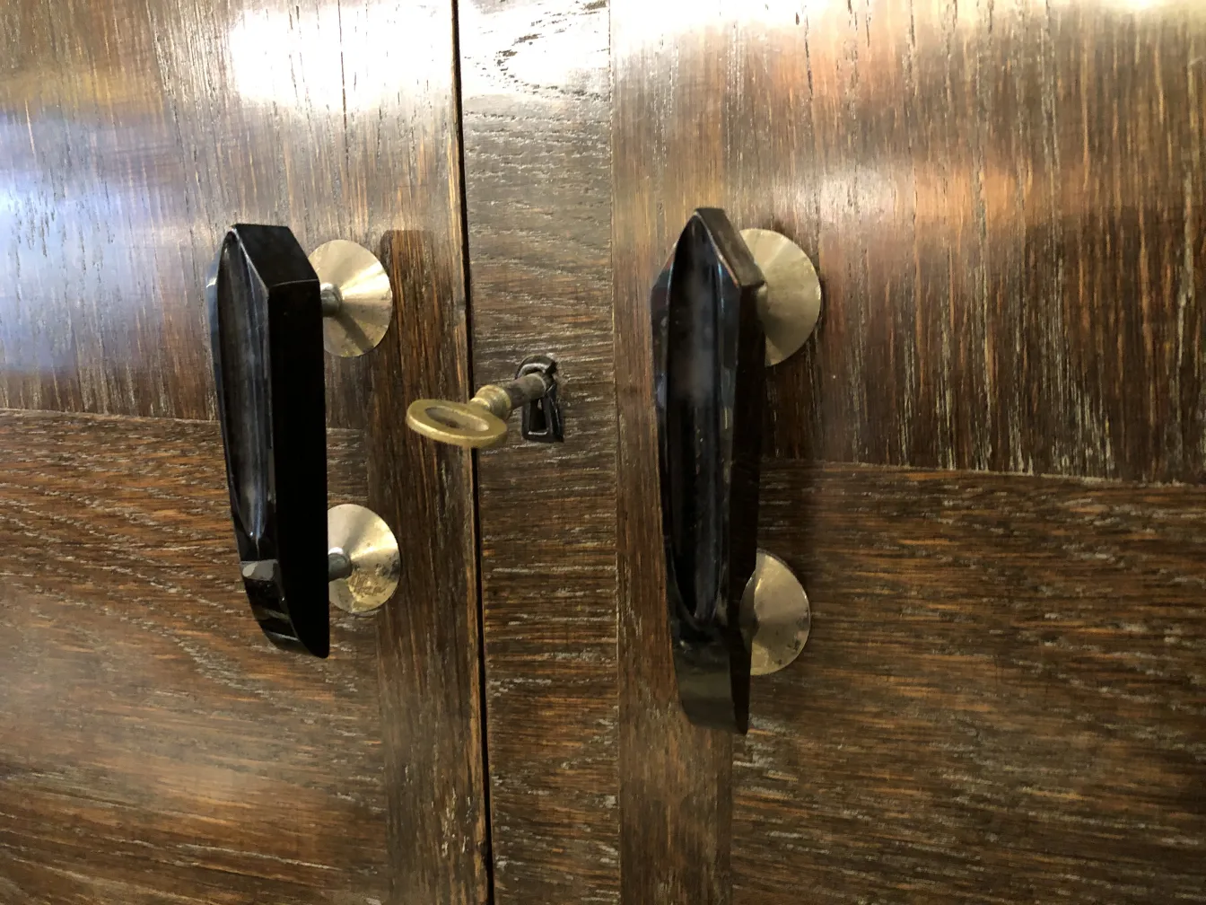 Meuble à cocktail ancien avec finition en bois et détails métalliques.