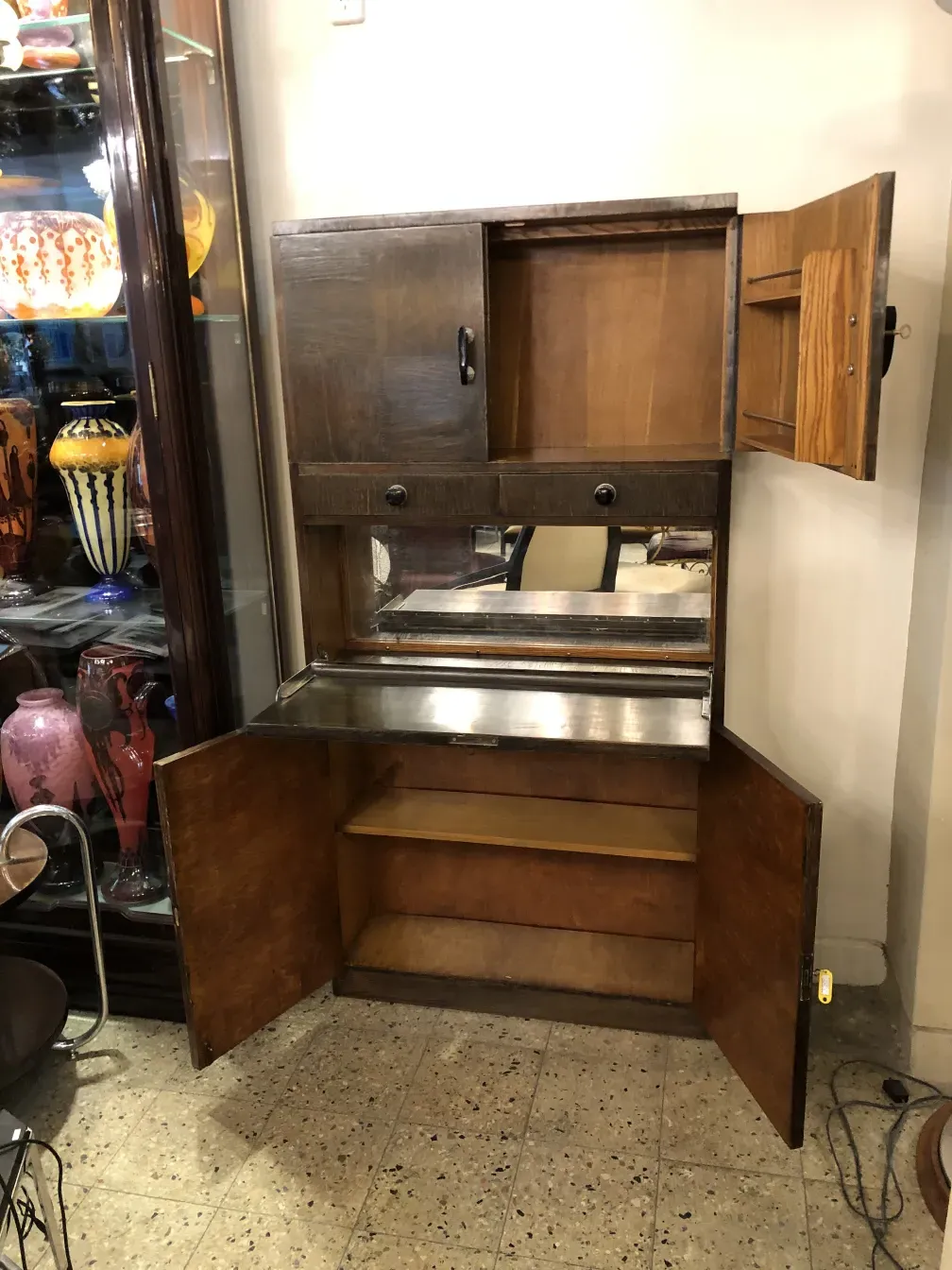 Antiguo mueble bar con compartimentos y espejo, decorado. Ambiente de bar acogedor.