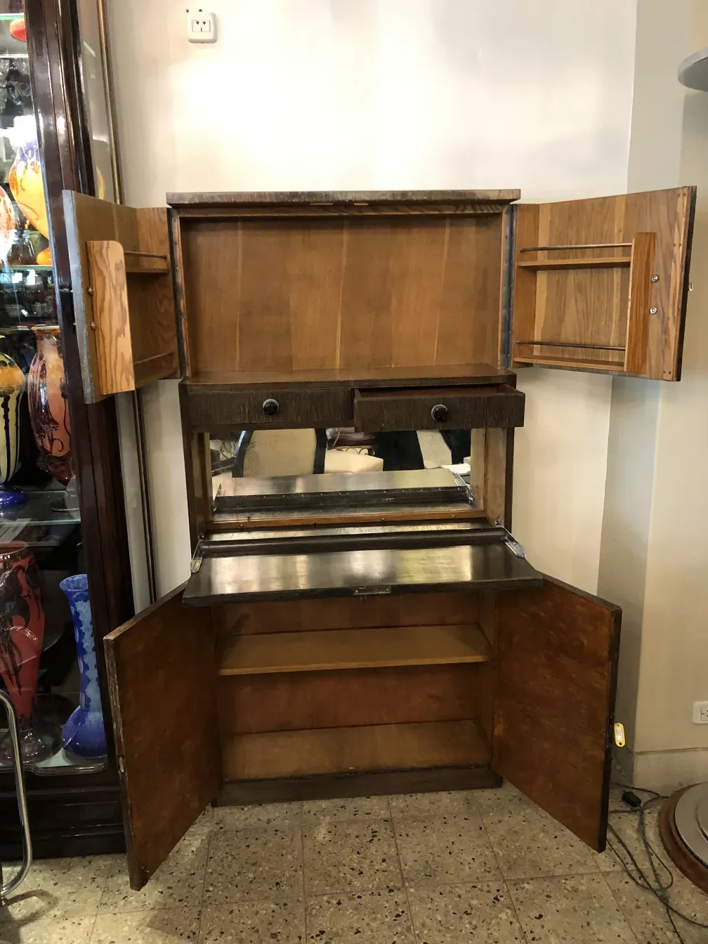 Antique bar with a mirror and two wooden drawers in an elegant setting.