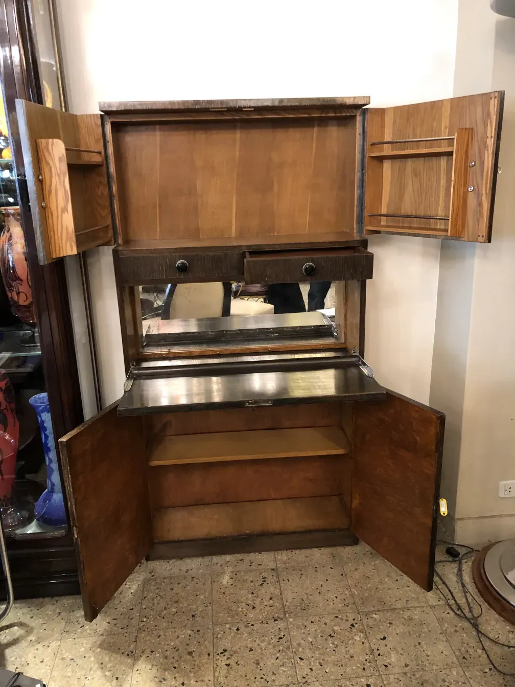 Mueble bar antiguo con espejo y detalles de madera clara en un entorno acogedor.