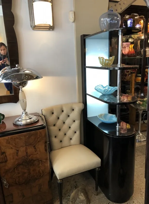 Mueble bar antiguo con estantes de vidrio y decoración