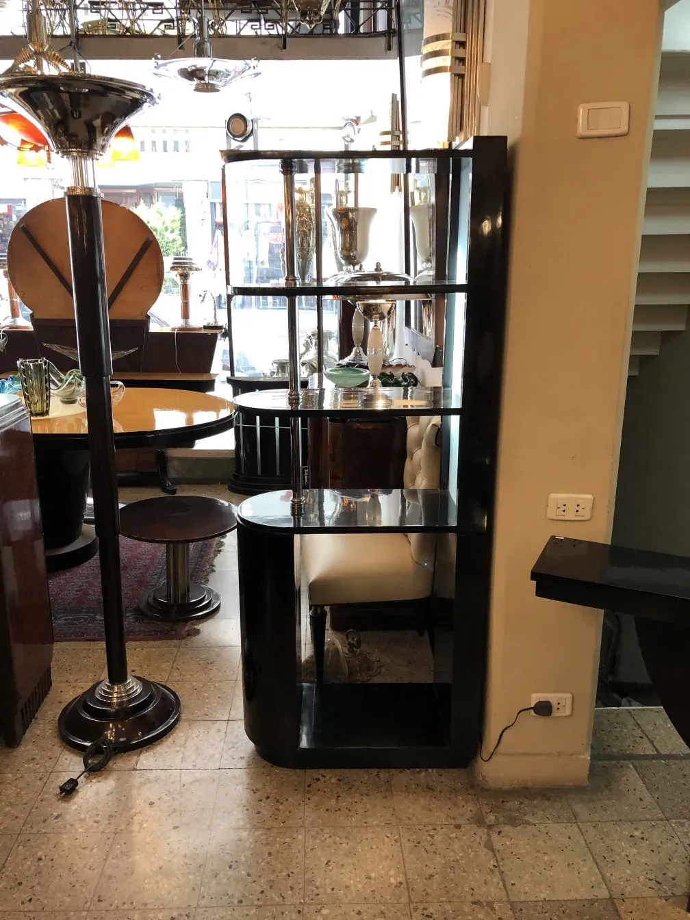 Mueble bar antiguo de madera con decoraciones, rodeado de objetos decorativos.